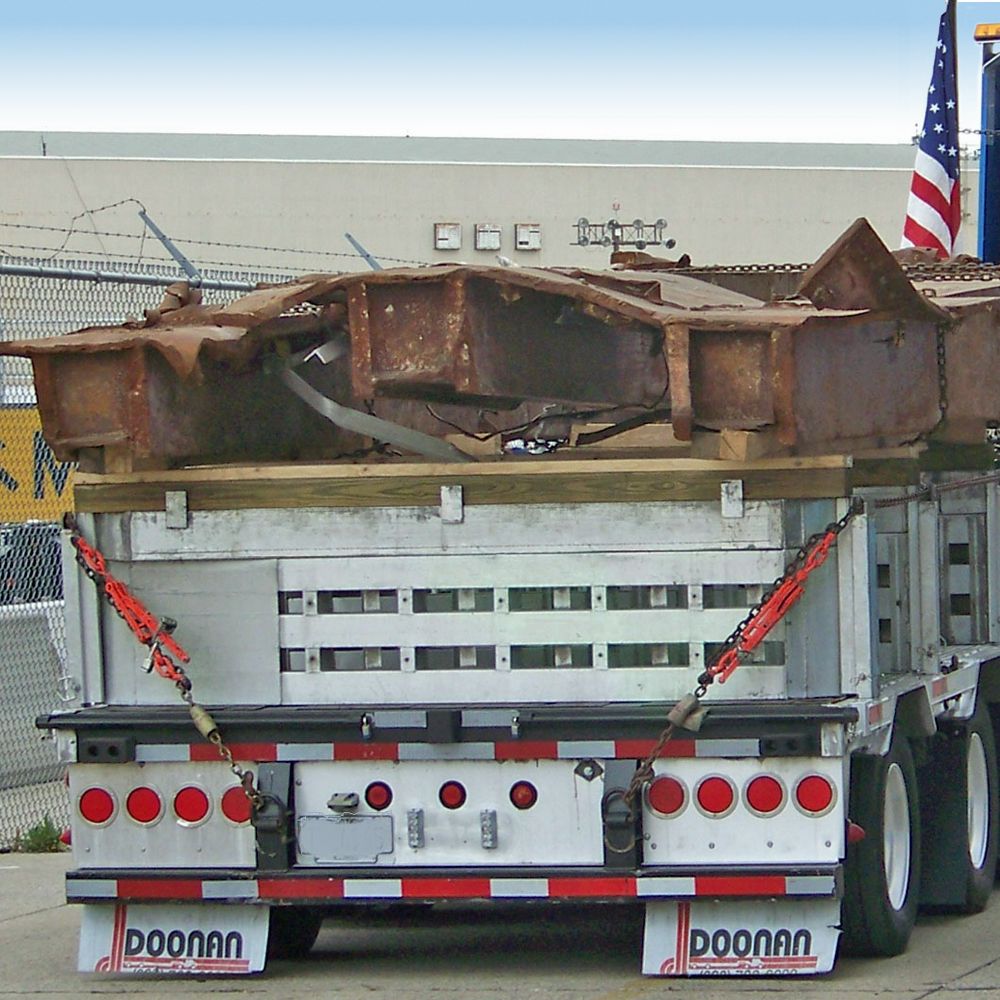 Step deck hauling steel with load leveler and spacer on Doonan trailer
